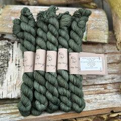 A pile of skeins of dark green yarn