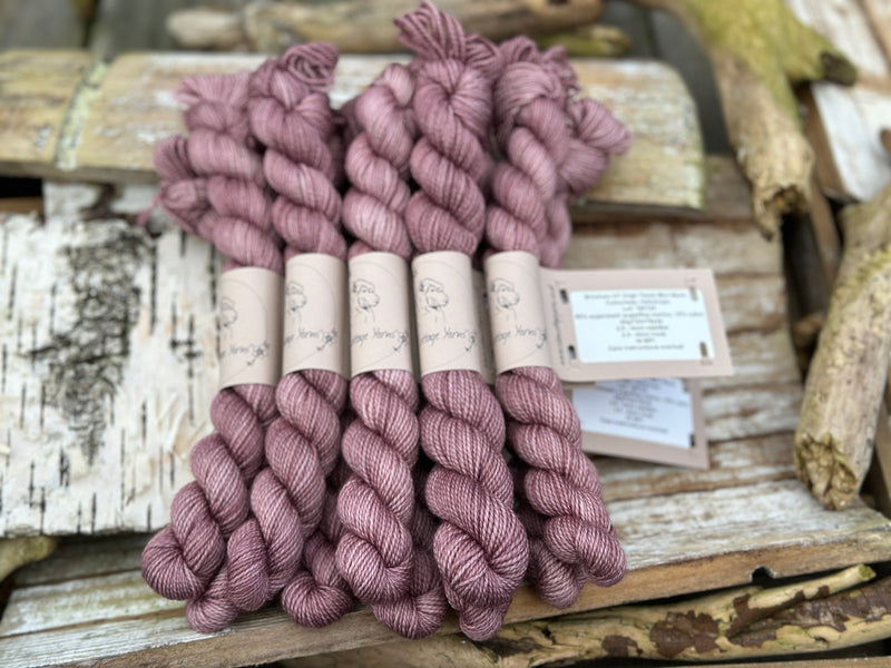 A pile of mini skeins of pinky purple yarn