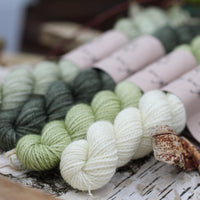 Four mini skeins of yarn in shades of green
