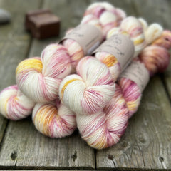 Five skeins of variegated cream, yellow and purple yarn