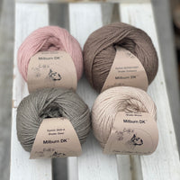 Four balls of yarn in two piles of two balls. On the left there is a pink ball and a brown ball. On the right there is a grey balls and a beige ball