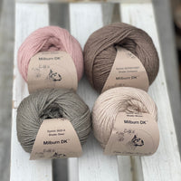 Four balls of yarn in two piles of two balls. On the left there is a pink ball and a brown ball. On the right there is a grey balls and a beige ball