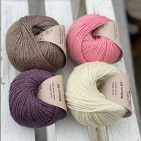 Four balls of yarn in two rows of two balls. There is a bright pink ball, a cream ball, a brown ball and a dark purple ball