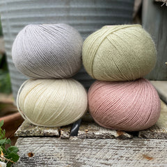Four balls of Milburn. On the top row is a pale blue ball and a pale green ball. On the bottom row is a cream ball and a pale pink ball