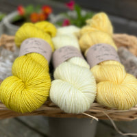 Three skeins of yarn in shades of yellow