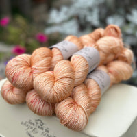 Five skeins of orange yarn with pink speckles
