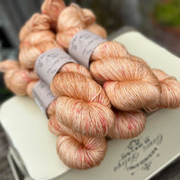 Five skeins of orange yarn with pink speckles