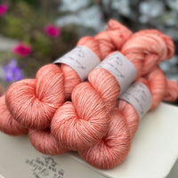 Five skeins of orangey pink yarn