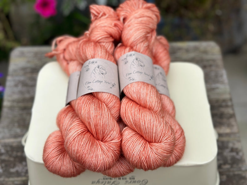 Five skeins of orangey pink yarn