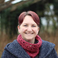 Victoria wearing a blue coat and a red crochet cluster cowl