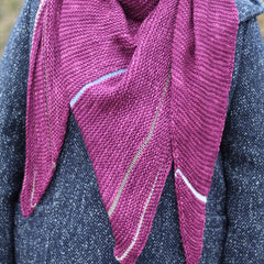 Victoria wearing a purpley pink triangular shawl wrapped around her neck. The shawl has stripes in muted contrast colours