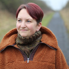 Victoria wearing a brown fleece and a variegated brown cowl with a single cable up the front.