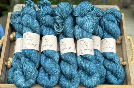 Skeins of rich blue yarn with white slubs of linen running through it