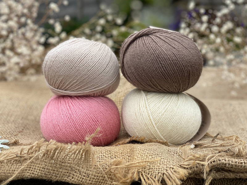 Four balls or Milburn. On the top row is a beige ball and a brown ball. On the bottom row is a pink ball and a cream ball