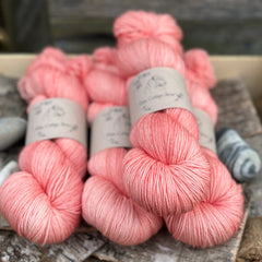 Four skeins of orangey pink yarn
