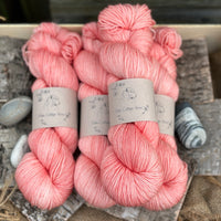 Four skeins of orangey pink yarn