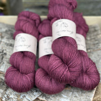 Four skeins of dark purple yarn