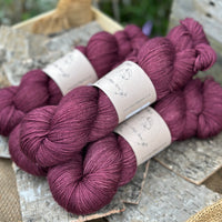 Four skeins of dark purple yarn