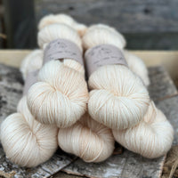 Five skeins of cream coloured yarn