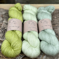 Three skeins of yarn in shades of green