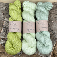Three skeins of yarn in shades of green