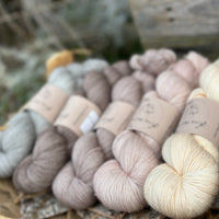 Five skeins of yarn in neutral shades