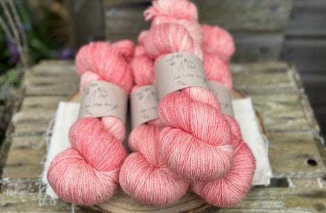 Four skeins of pale pink yarn with silver sparkle running through it