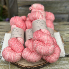 Four skeins of pale pink yarn with silver sparkle running through it