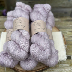 Five skeins of pale purple yarn with silver stellina sparkle running through it