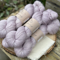 Five skeins of pale purple yarn with silver stellina sparkle running through it