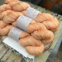 Five skeins of orange yarn with silver stellina sparkle running through it