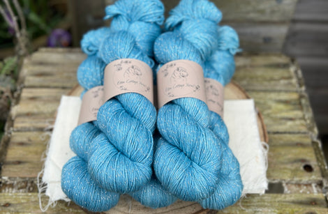 Five skeins of bright blue yarn with silver stellina running through it