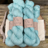 Five skeins of pale blue yarn with silver stellina running through it