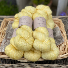 Five skeins of yellow yarn with gold sparkle running through it