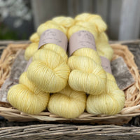 Five skeins of yellow yarn with gold sparkle running through it