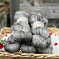 Five skeins of variegated grey yarn with red speckles