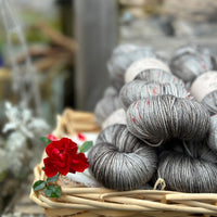Five skeins of variegated grey yarn with red speckles