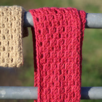 Two crochet cluster cowls, one in a bright pink and one in a sand colour