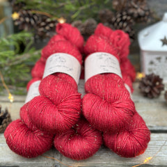 Five skeins of red yarn with fine gold sparkles running throughout