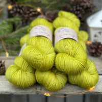 Five skeins of zingy green yarn with fine gold fibres running throughout