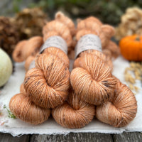 Five skeins of orange yarn with dark speckles