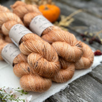 Five skeins of orange yarn with dark speckles
