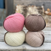 Four balls of yarn. Colours are natural cream, beige, pink and brown