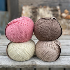 Four balls of yarn. Colours are natural cream, beige, pink and brown