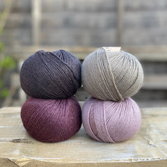 Four balls of Milburn. On the top row is a black ball and a grey ball. On the bottom row is a purple ball and a pale purple ball