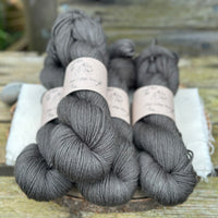 Four skeins of dark grey yarn