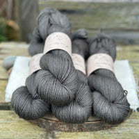 Four skeins of dark grey yarn