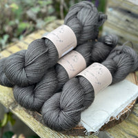 Four skeins of dark grey yarn