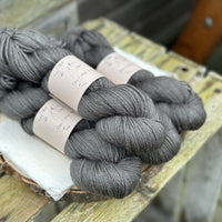 Four skeins of dark grey yarn