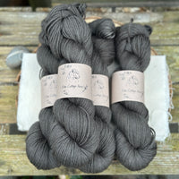 Four skeins of dark grey yarn